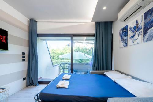 a bedroom with a blue bed and a table at Desenzano - 2' to Station & Lake - Pool, Wifi, AC in Desenzano del Garda
