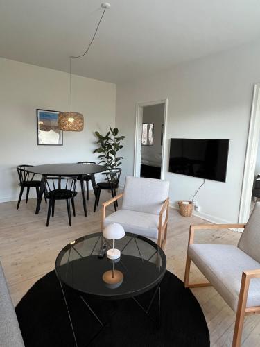 a living room with a couch and a table at Hyggelig lejlighed tæt på centrum og letbanestop in Odense