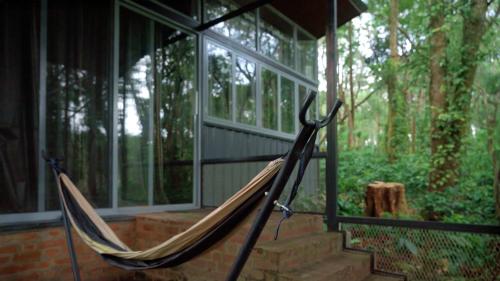 a hammock on the porch of a house at Cove by Raho - Nestled Away Retreat in Siddapur