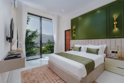 a bedroom with a large bed with a green wall at Orbit88 Hotel by AMR in Kandy
