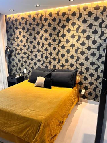 a bedroom with a gold bed with a patterned wall at Art studio DA in Salvador