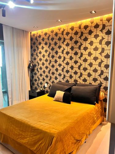 a bedroom with a yellow bed with a wall at Art studio DA in Salvador