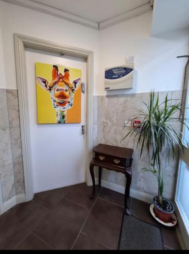 a hallway with a door with a painting of a giraffe at Mariners Rest One Bedroom Apartment in Innishannon Village in Cork