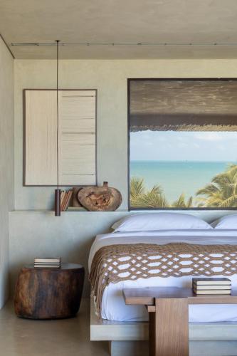 a bedroom with a bed with a view of the ocean at Mana Cumbuco Hotel in Cumbuco