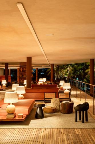 a lobby with tables and chairs in a building at Mana Cumbuco Hotel in Cumbuco