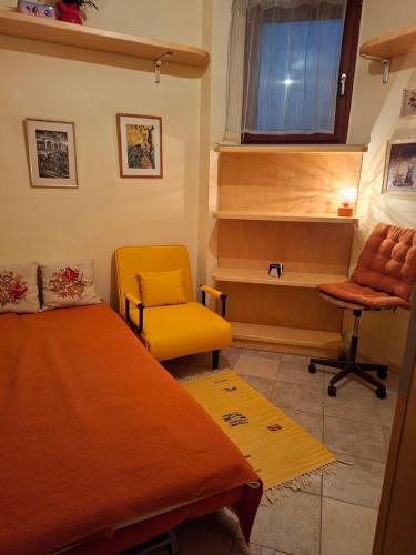 a room with a bed and a chair and a table at ANERI in Ljubljana
