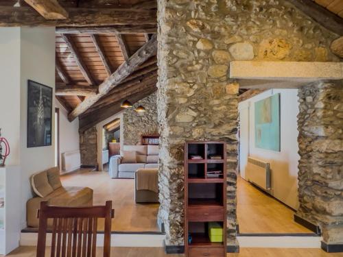 a living room with a stone wall at Cal 1777 in Bourg-Madame