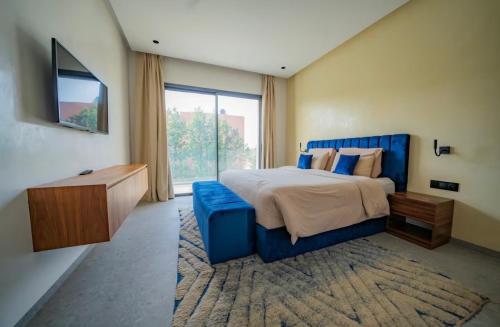 a bedroom with a blue bed and a large window at Villa Horizon in Marrakesh