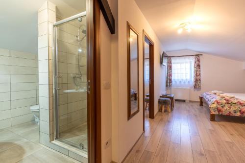 a bathroom with a glass shower and a bedroom at Pensiunea Casa Brancovenilor in Sâmbăta de Sus