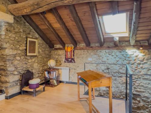 a room with a table and a stone wall at Cal 1777 in Bourg-Madame