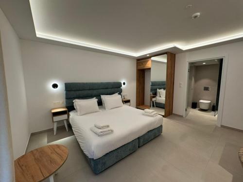 a bedroom with a large white bed and a table at Hypnos Boutique Hotel in Nicosia