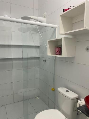 a white bathroom with a toilet and a shower at Pool house próximo ao centro in Matinhos