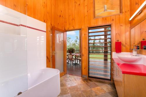 a bathroom with a white tub and a sink at Lake Tinaroo Waterfrontage in Barrine
