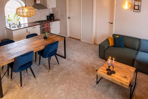 a living room with a table and a couch at Hoeve de Binnenplaets - Appartementen - Glamping - Familieverblijf in Schimmert