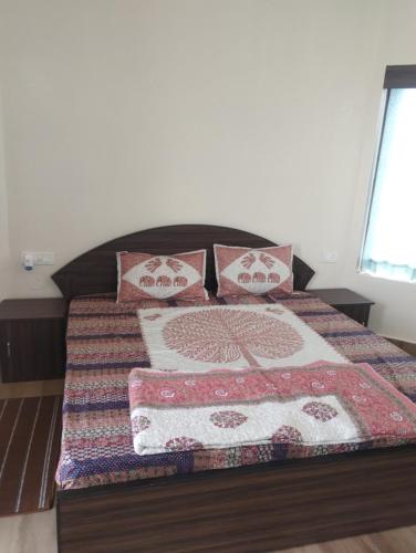 a bed with a quilt and pillows on it at Maanjoofarms Pilani in Pilani