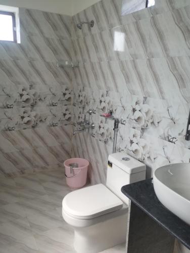 a bathroom with a toilet and a sink at Maanjoofarms Pilani in Pilani