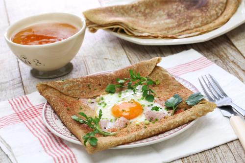an egg and toast on a plate with a bowl of soup at Camping Saint-Gildas-de-Rhuys in Saint-Gildas-de-Rhuys