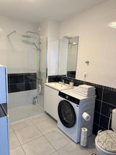 a washing machine in a bathroom with a sink and a shower at Appartement de standing, parking privé, climatisé, proche du centre-ville et la gare centre in Avignon