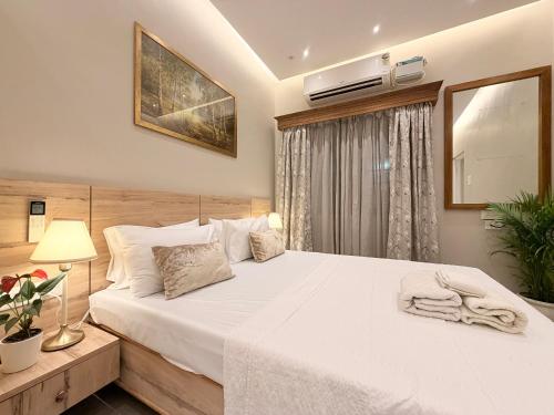a bedroom with a large white bed and a window at MILANO By The Beach Goa in Benaulim