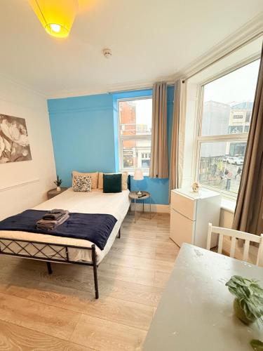 a bedroom with a bed and a blue wall at Wandsworth Guest Rooms 64 in London