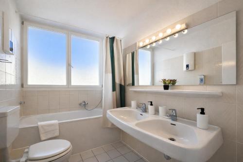 a white bathroom with a sink and a toilet at Representative City Villa in Meerbusch
