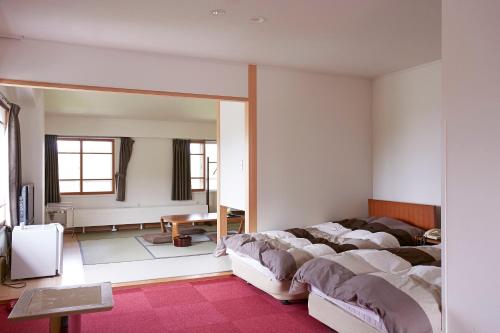 a bedroom with a bed and a mirror at Shiga Lake Hotel in Yamanouchi