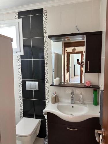 a bathroom with a sink and a toilet and a mirror at Eos in Çeşme