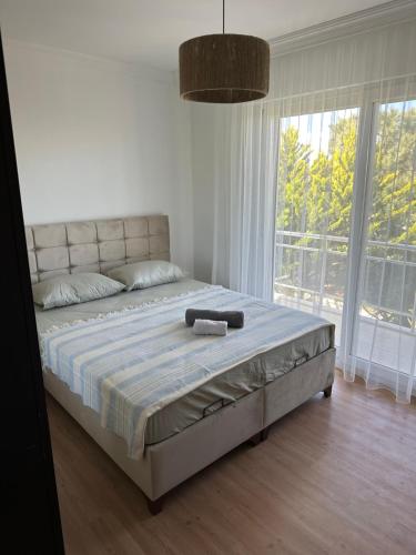 a large bed in a bedroom with a large window at Eos in Çeşme