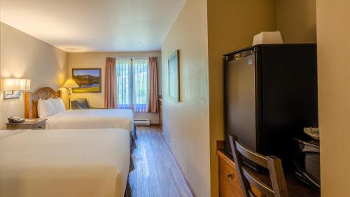 a hotel room with two beds and a refrigerator at Cahilty #313 home in Sun Peaks