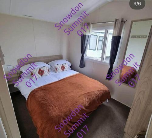 a bedroom with a bed with two dogs on the pillows at Snowdon Summit 017 in Barmouth