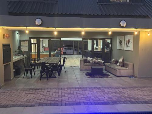 a living room with couches and a table and chairs at House 110 in Hoedspruit
