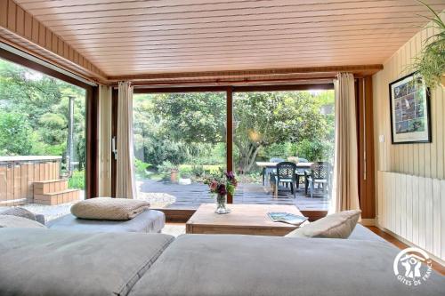two beds in a room with a view of a patio at Au blavet douillet in Lochrist