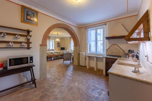 a kitchen with an archway and a living room at B&B Il Molinello in Asciano