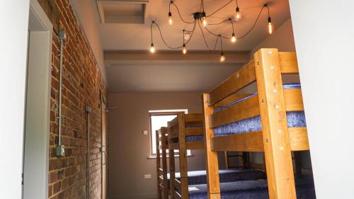 a room with bunk beds and a brick wall at 3 Peaks Bunkroom in Settle