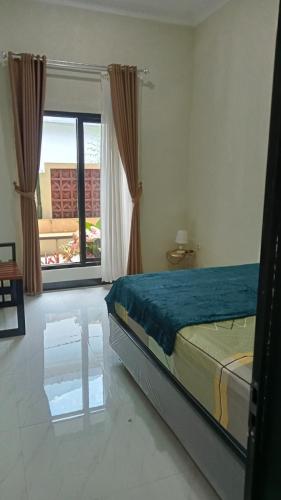 a bedroom with a bed and a large window at Kulla villa dieng in Wonosobo