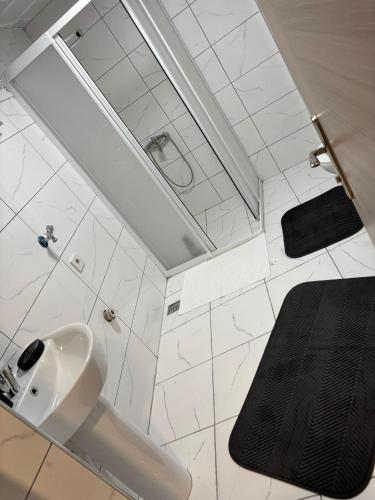 a white bathroom with a sink and a mirror at Kent KONAKLAMA in Uşak