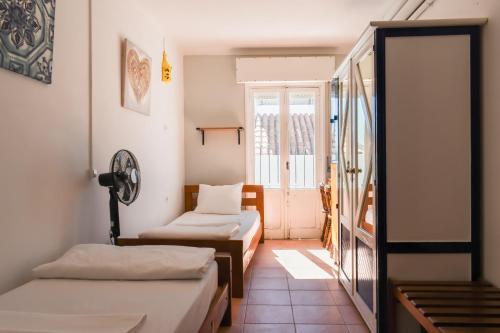a room with two beds and a window at Lagos Central Hostel in Lagos