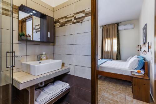 a bathroom with a sink and a bed at Studios Galini in Skopelos Town