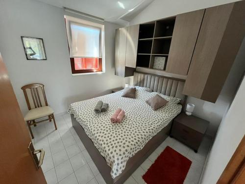 a small bedroom with a bed and a chair at Apartmani Hranjec in Ugljan