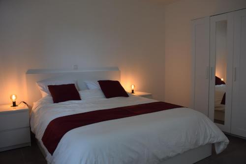 a bedroom with a large white bed with two lamps at 't Wellement in Denderleeuw