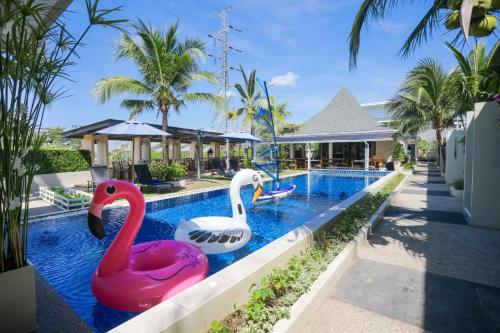 two swans in a swimming pool at a resort at Impress Resort in Thalang