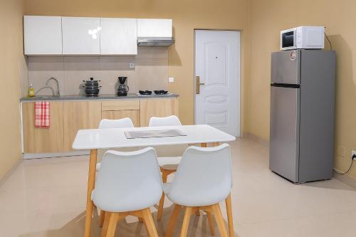 a kitchen with a white table and a refrigerator at Milestone Villa in Antananarivo