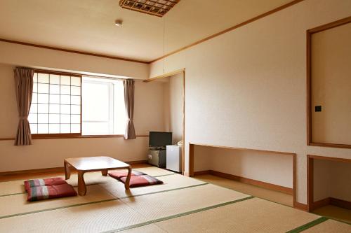 an empty room with a table and a window at Shiga Lake Hotel in Yamanouchi