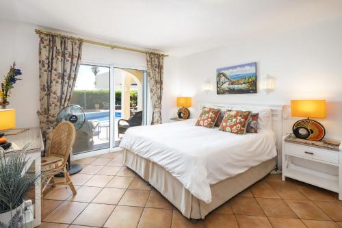 a bedroom with a bed and a sliding glass door at Casa Juniper in Praia do Carvoeiro