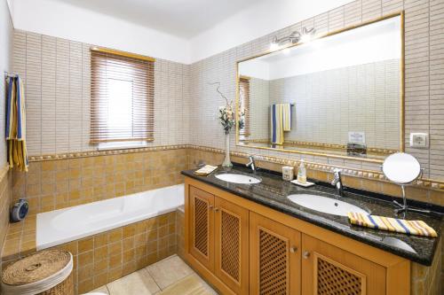 a bathroom with two sinks and a large mirror at Casa Juniper in Praia do Carvoeiro