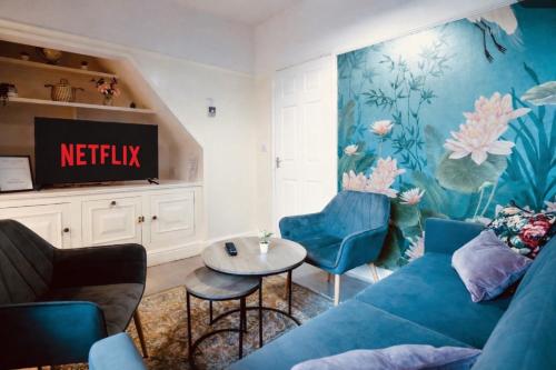 a living room with a blue couch and a table at Home away from home-business & leisure travellers in Northampton