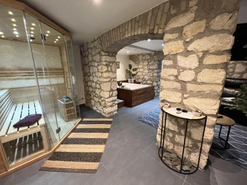 a bathroom with a stone wall and a bath tub at Appart Spa Privatif in Reims