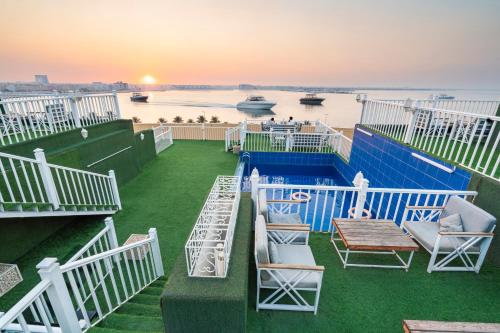 a balcony with chairs and a table and a view of the water at Golden Garden Al Corniche in Dammam