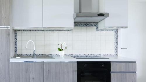 a white kitchen with a sink and a sink at Apartments King and Queen 2 in Povile