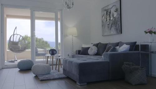 a living room with a blue couch and a large window at Apartments King and Queen 2 in Povile